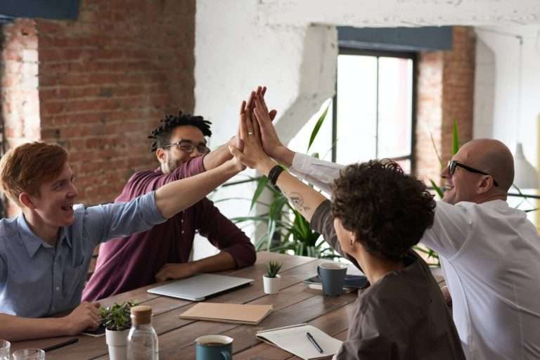 People at table with hands extended